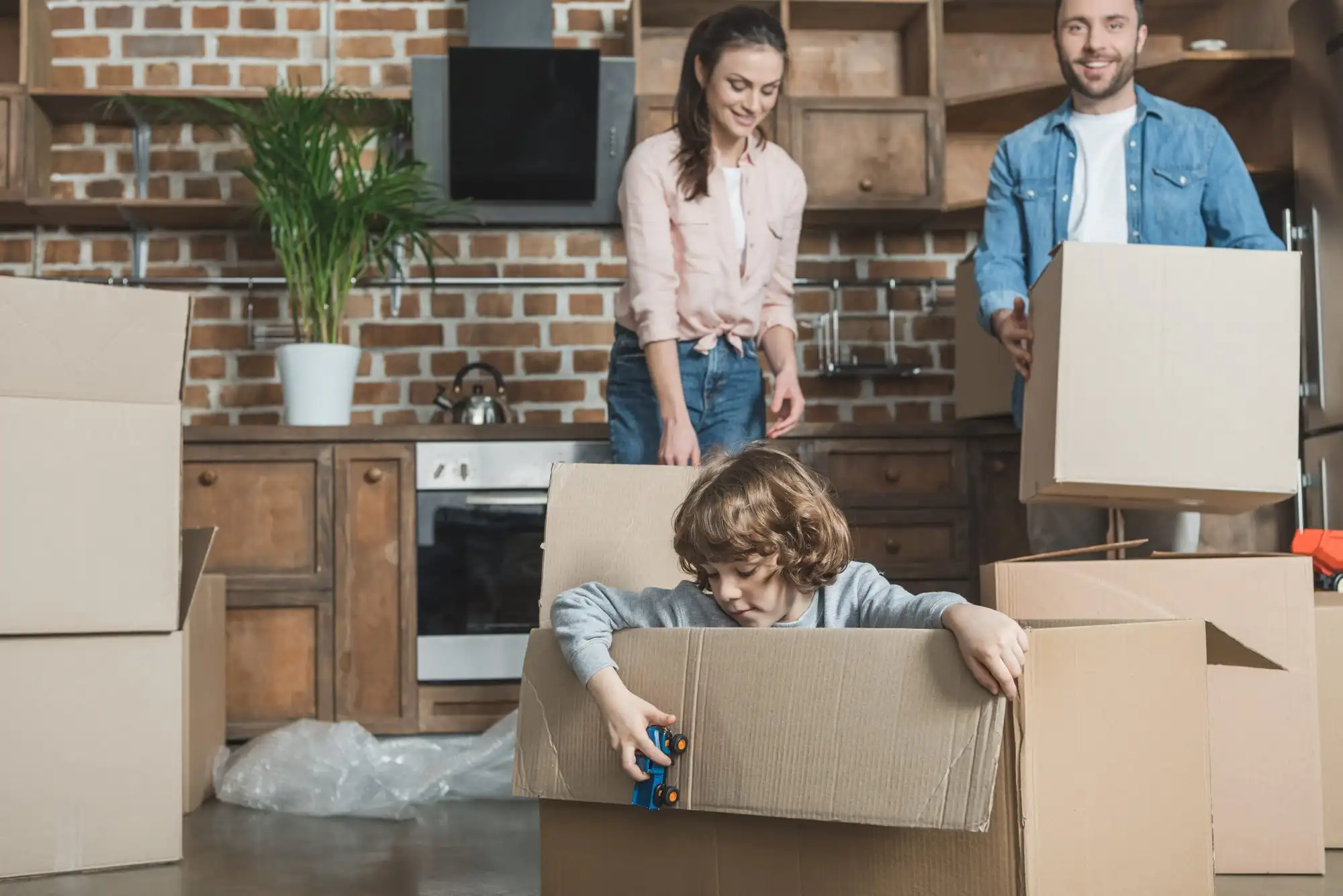 A family standing with moving boxes in a new home