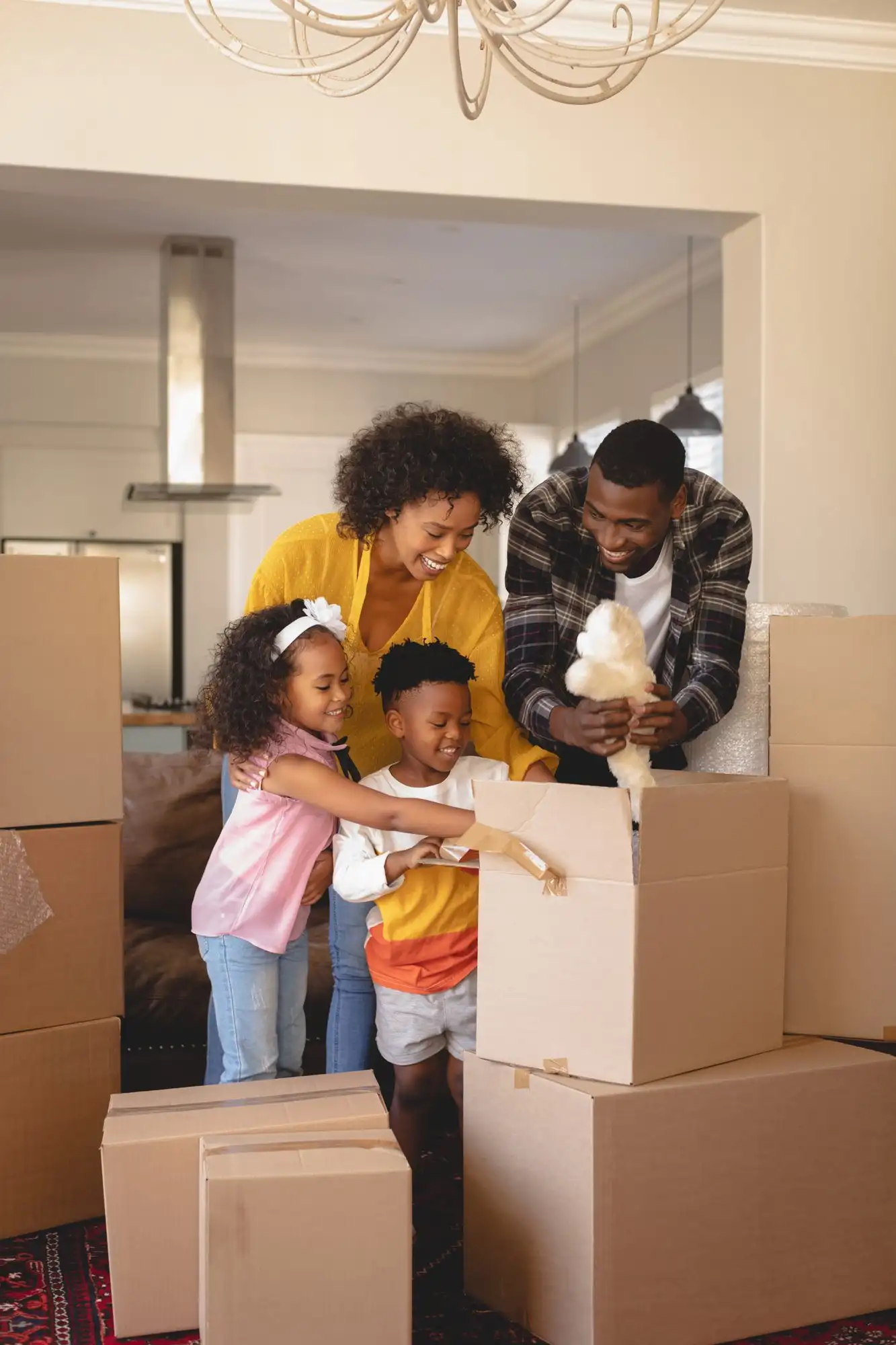 A family carrying boxes into a new home