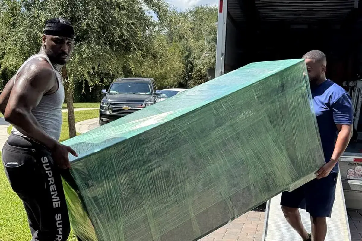 Toro Movers crew carrying a padded item on a real residential home move