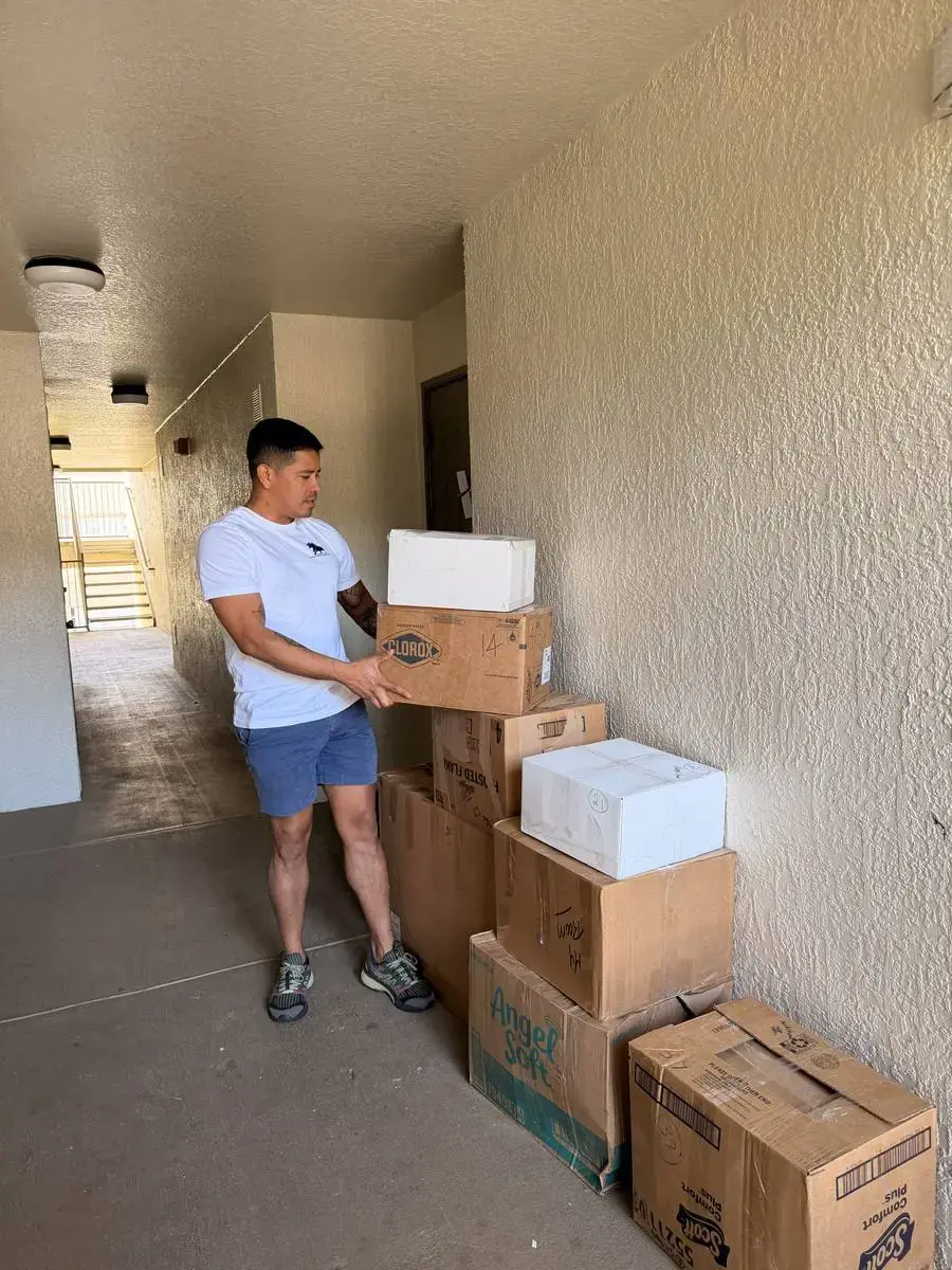 Toro Movers crew carrying boxes in an apartment hallway on a local move